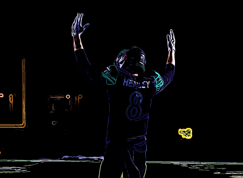 Coach Tyler Henley with raised arms in a touchdown signal gesture.